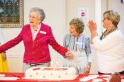Mary Jo and Joan cut the cake while Marilyn applauds